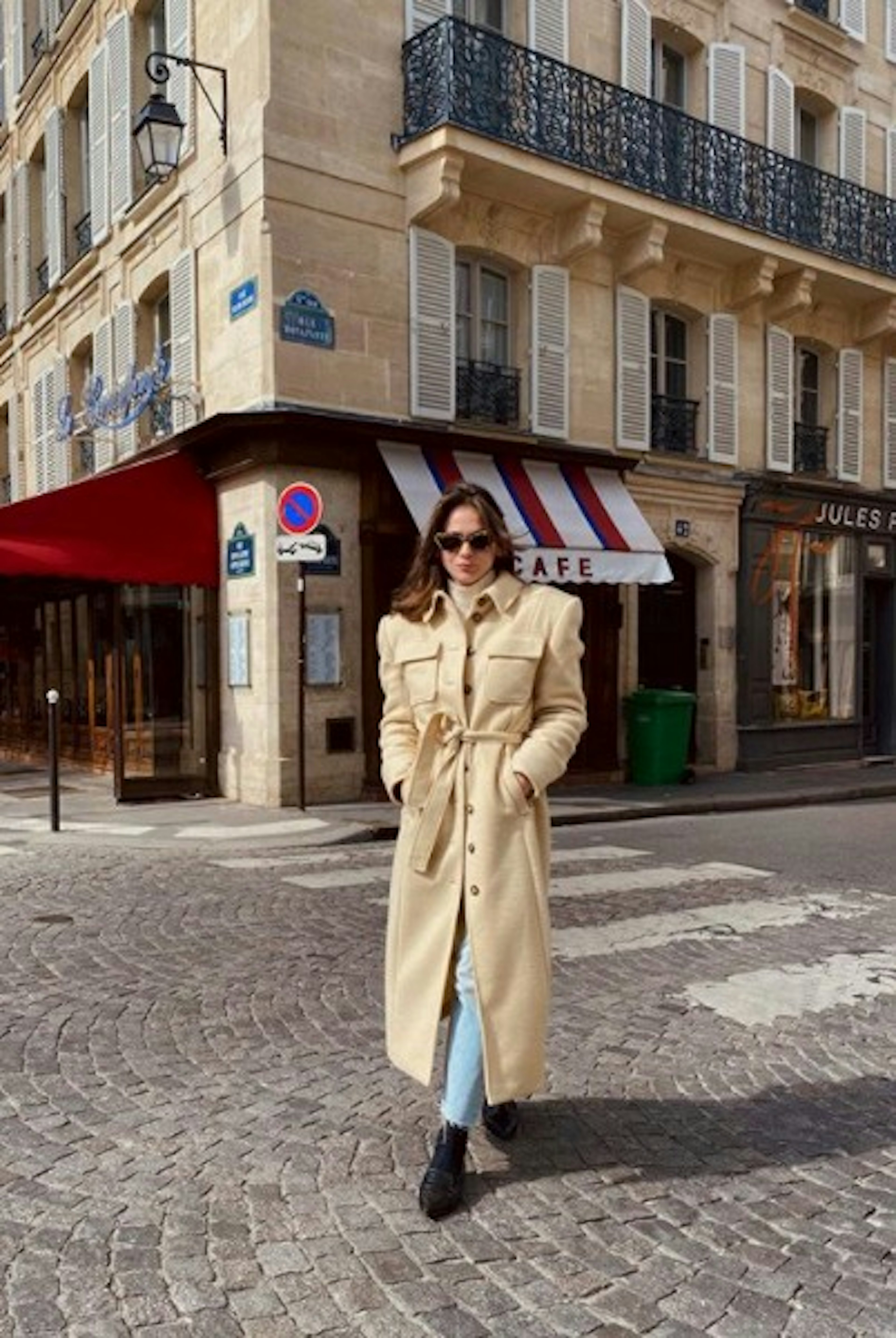 Thérèse walking around the streets of Paris. Here she is wearing the Victoire Coat from AÉRYNE. image